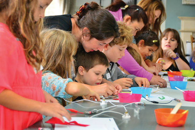 children with teacher making things with craft materials